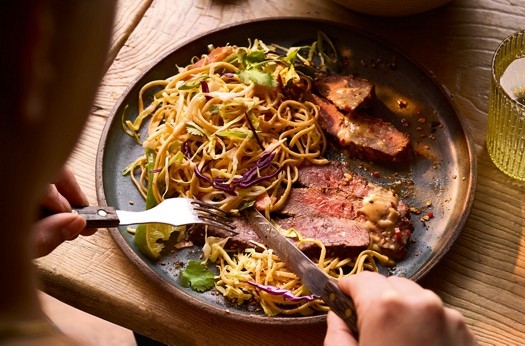 Black pepper & soy flat iron steak with noodle slaw and miso-peanut dressing