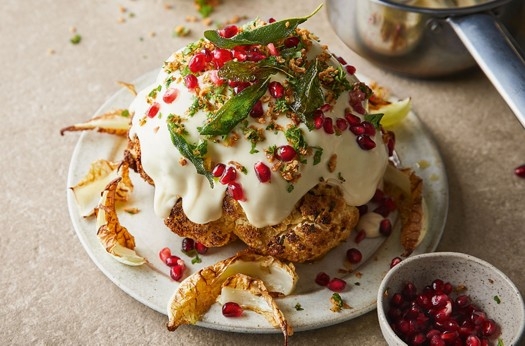 Whole cauliflower cheese with crispy onions, herbs & pomegranate