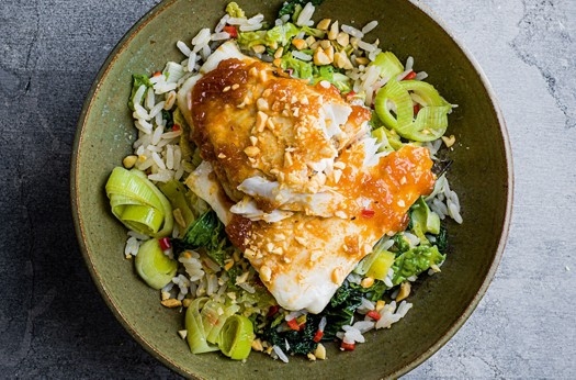 Roast hake with rice, greens & peanuts